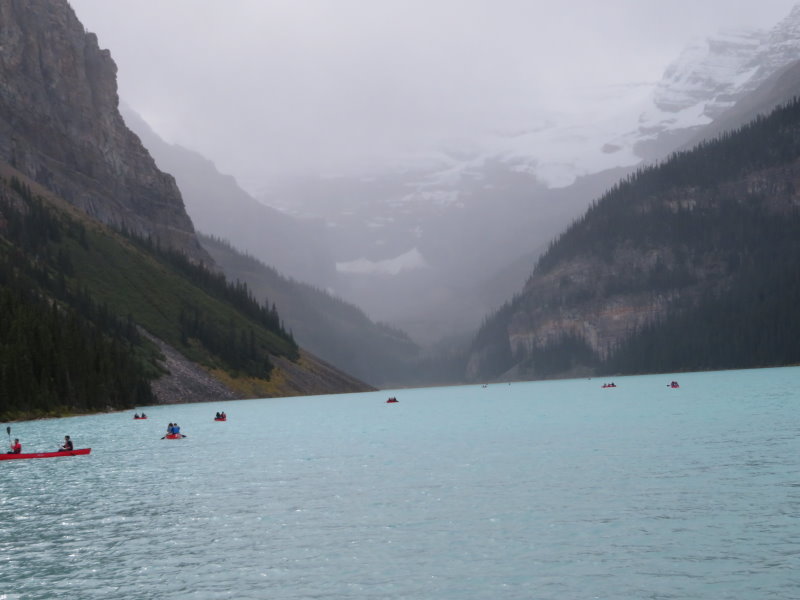 Lake Louise with the feeding glaciers visible through fog and rain, Keen canoers.